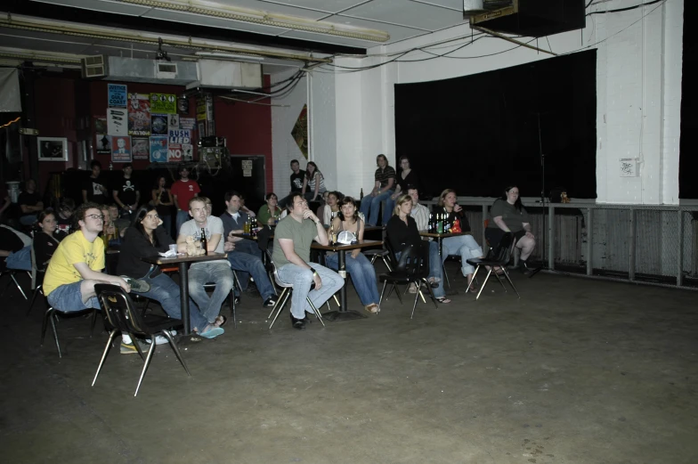 a group of people sitting in chairs drinking at their tables