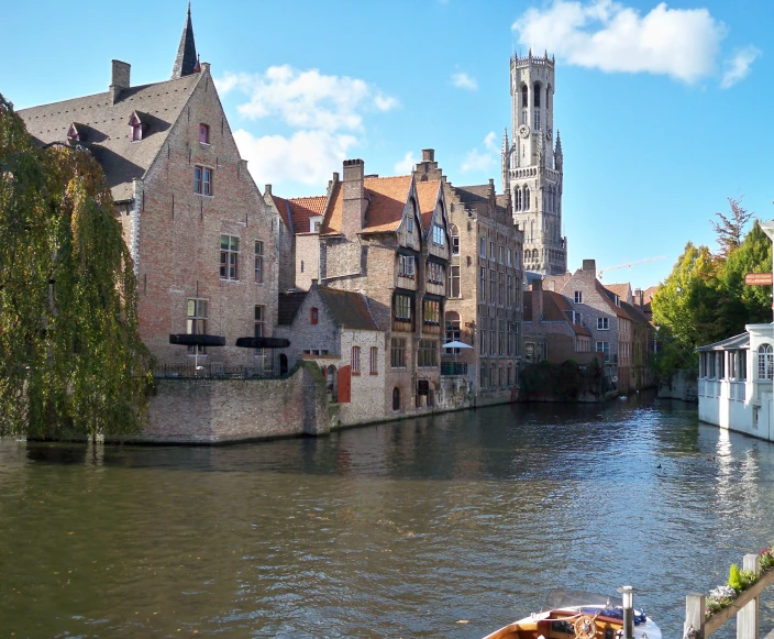 a boat is on a narrow waterway and houses line the river