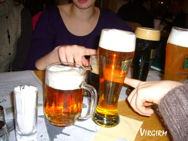 people at a table with many glasses of beer