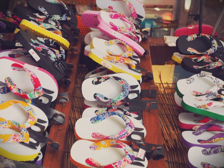 a variety of sandals for sale and a wooden rack with ribbons