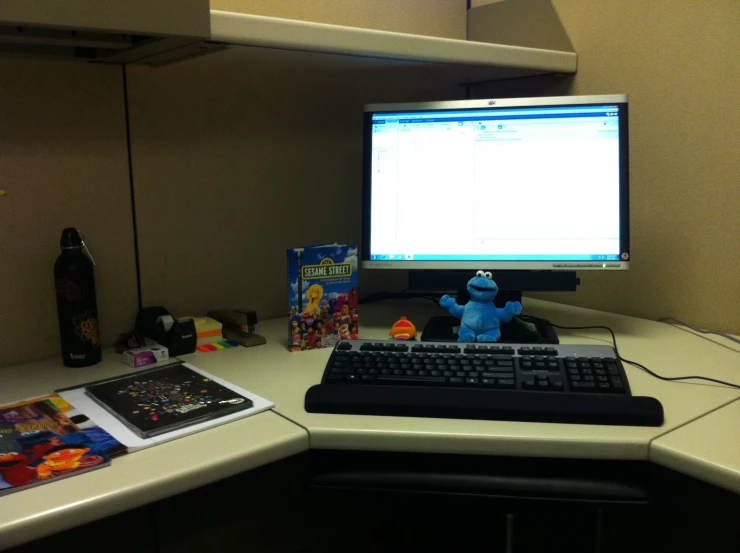 an office desk with the computer turned on and all accessories siting on it