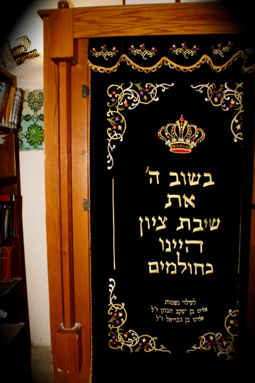 a black door with golden lettering near bookshelves