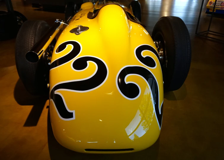 the rear view of a yellow racing car that has some designs on it