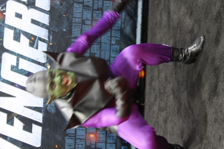 a person wearing a purple outfit and green costume
