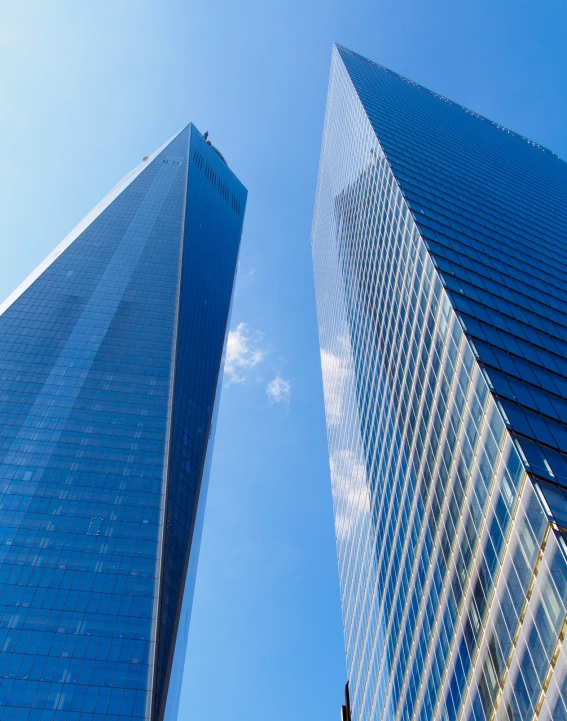 two very tall building next to each other on a sunny day