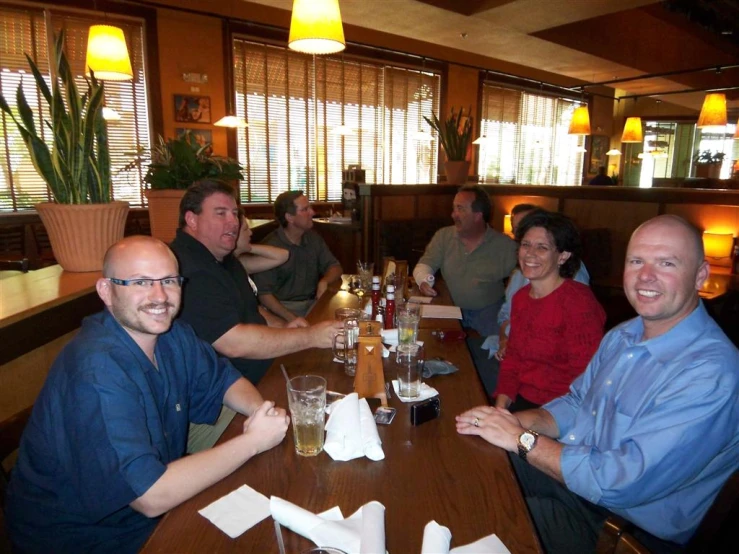 a group of people sitting at a long table