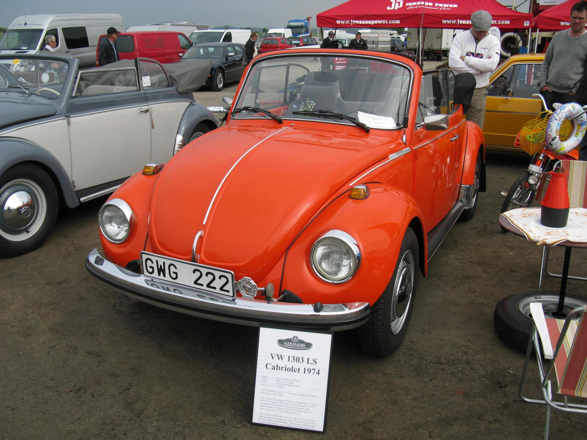 a orange vw bug sitting in the shade