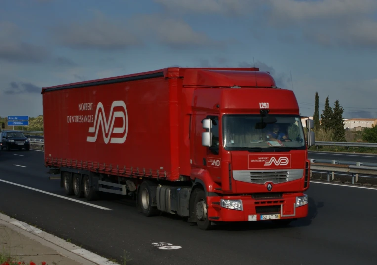 a red delivery truck driving down a highway