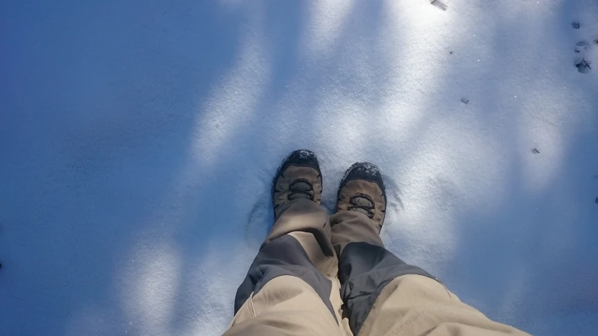 a person standing on some snow and shoes in the snow