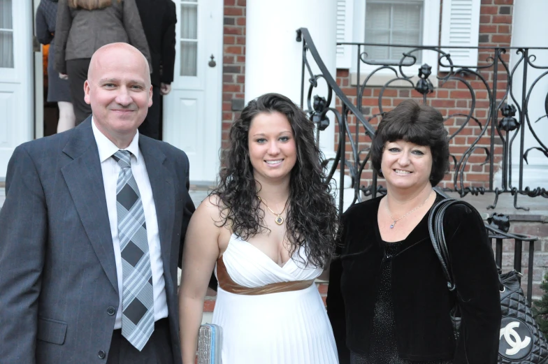 three people standing together outside of a building