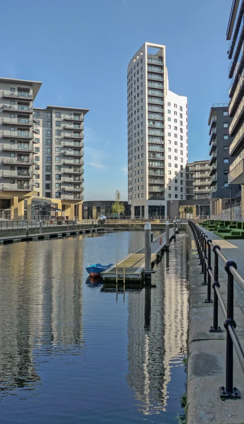 some buildings are reflected in the water and a small boat is out side