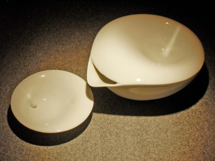 a pair of small white bowls next to each other