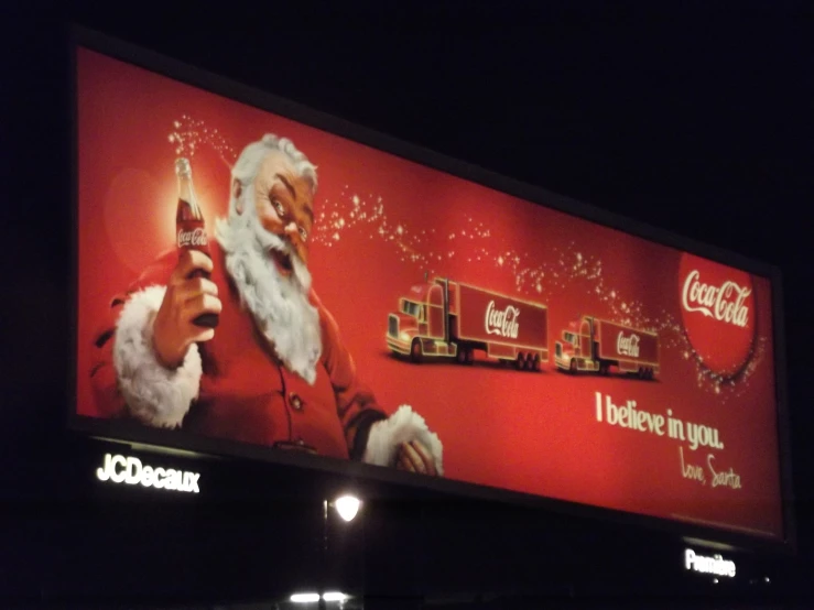 a lighted coca cola advertit with santa clause holding a bottle