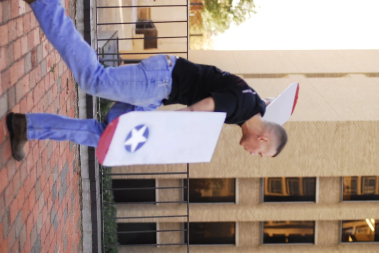 a man walks down a street carrying an open bag with a paper shaped like a flag and a paper bag with the image of a stars in it