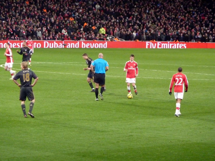 men in uniforms playing soccer on a field