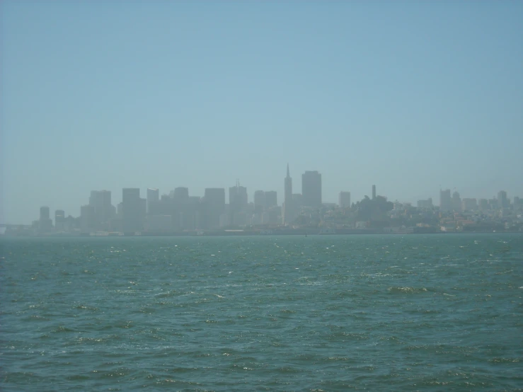 large city seen from water in the middle of blue sky