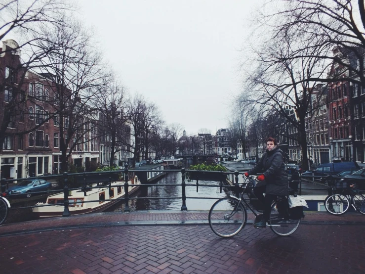 a man on his bicycle riding along the canal