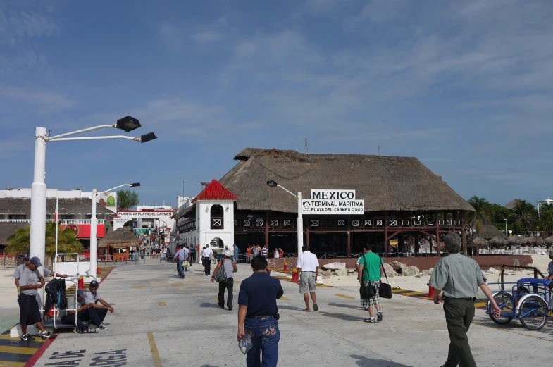 a group of people walking around near a small building