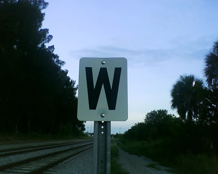 this street sign is posted on railroad tracks