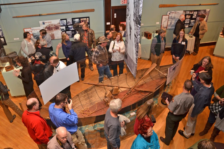 an overview of a museum filled with people viewing different items