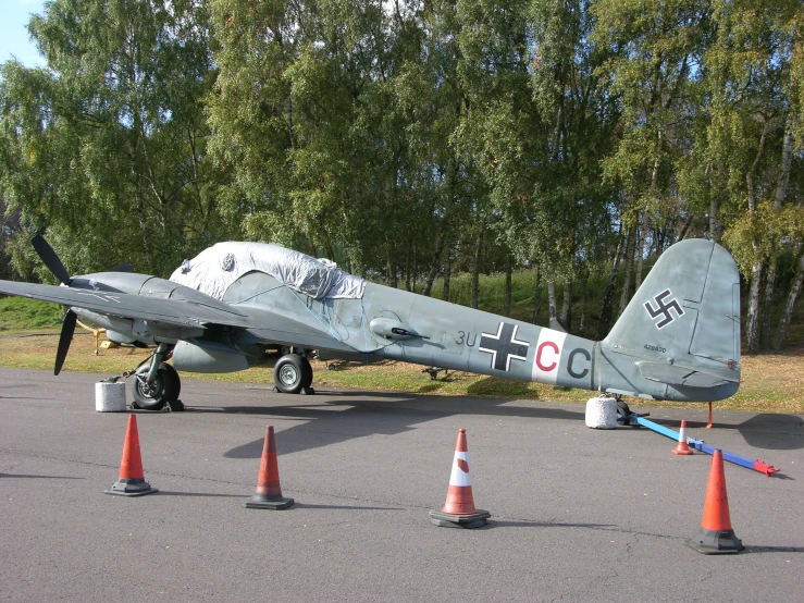 an old air plane is on display near cones