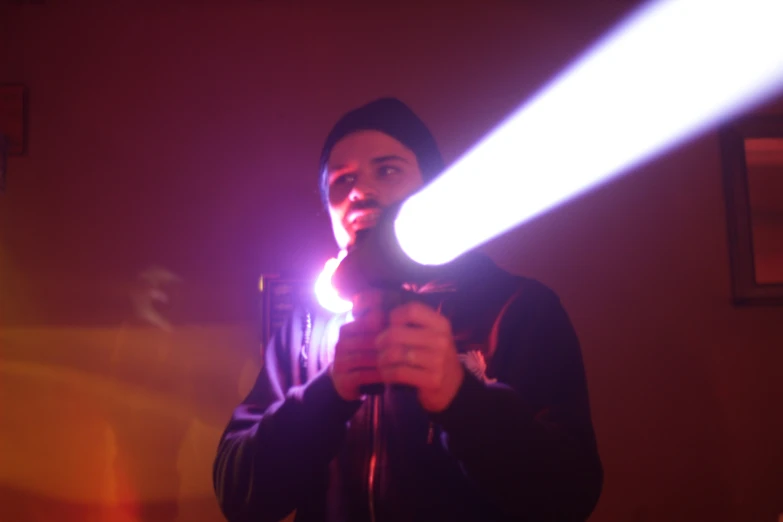 a person in a dark room holding a light and pointing at the light