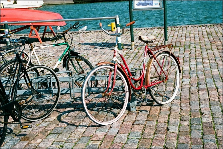 two red bikes parked next to each other near a body of water