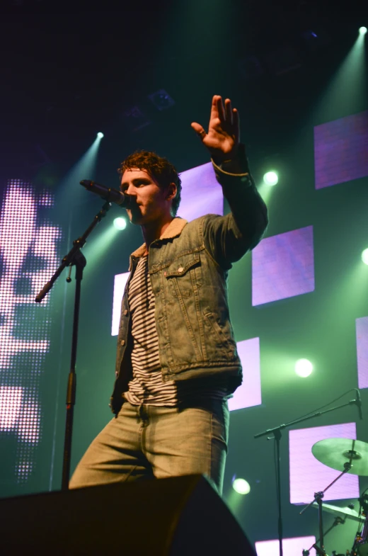 man wearing a blue jacket performing on stage