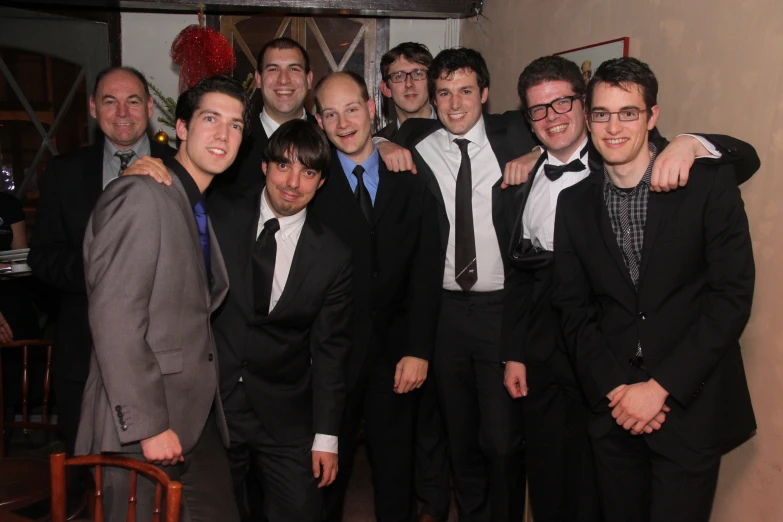 a group of young men in suits and ties pose for a po