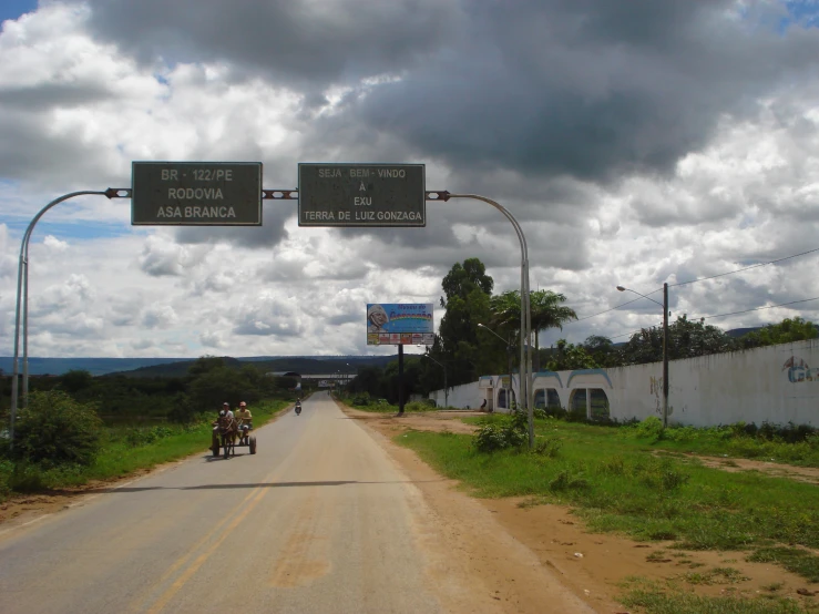 three people are on their bicycles on a rural road