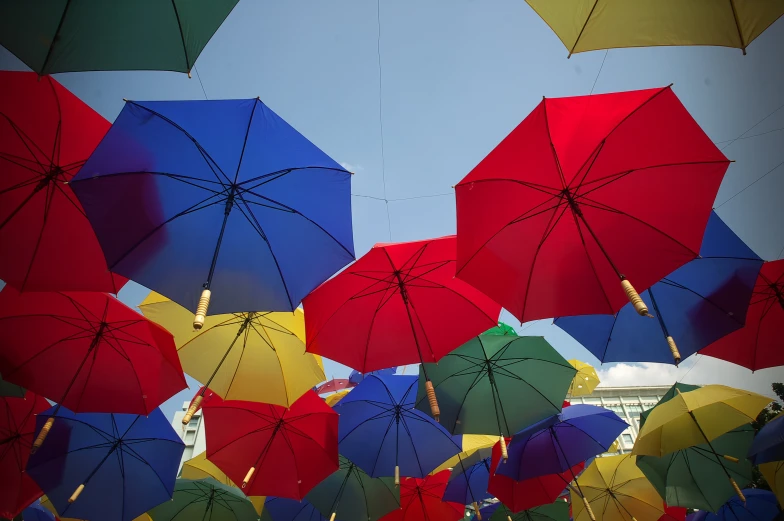 rows of different colored umbrellas set in the air