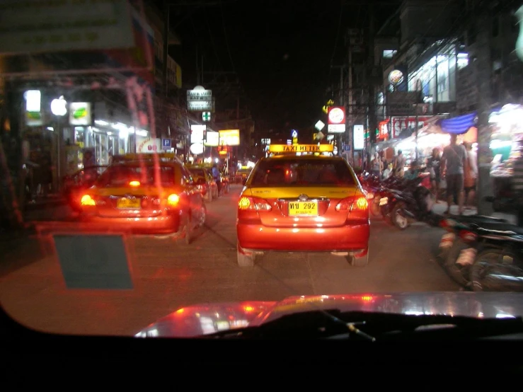 the back lights of some taxis driving down a street