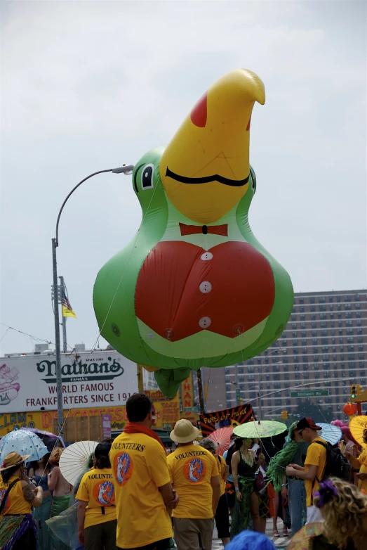 a group of people walking past some large balloons