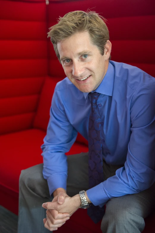 a man posing in a blue shirt and tie