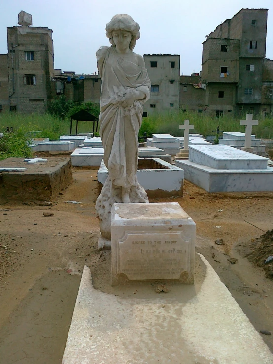 the statue is next to the grave in the field