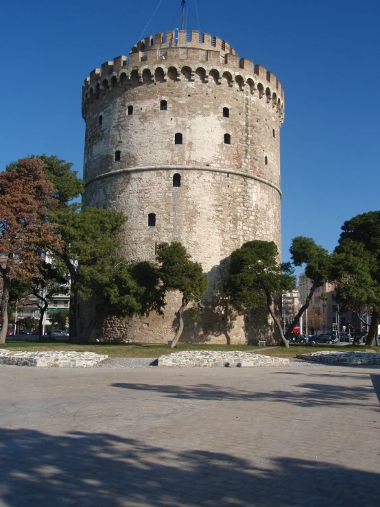 a big white tower sitting next to a tree filled park