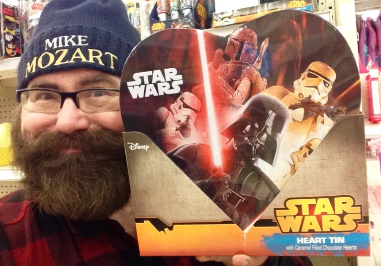 a bearded man is holding a star wars cardboard box