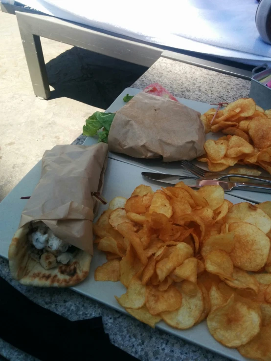 a lunch meal is on display with chips and vegetables