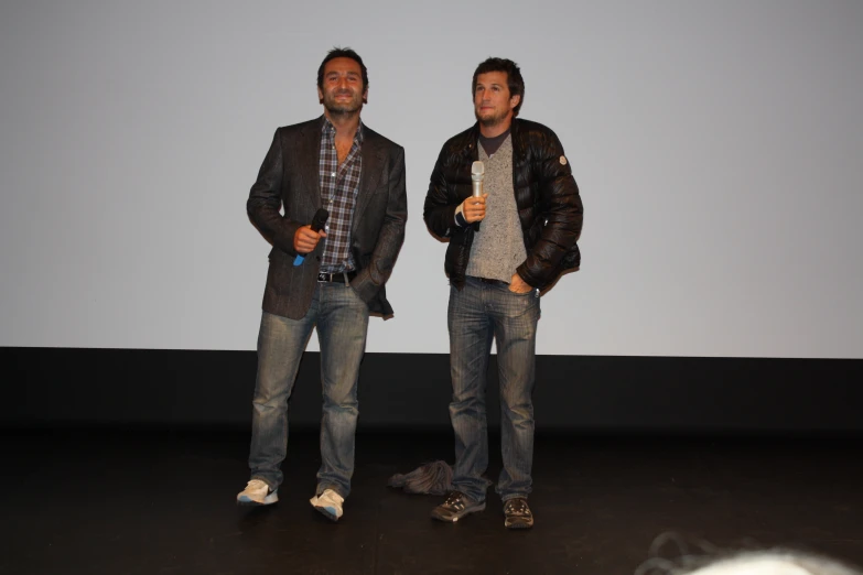 two young men in casual clothing standing next to each other