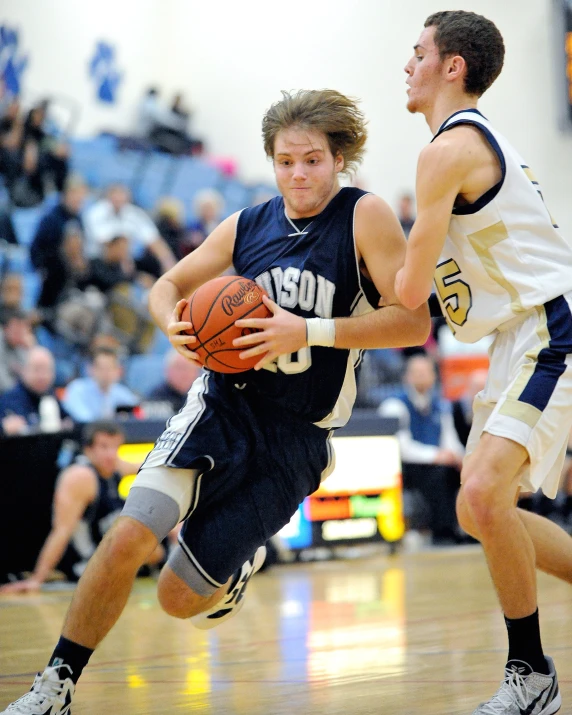 there is a male basketball player that has the ball in his hands