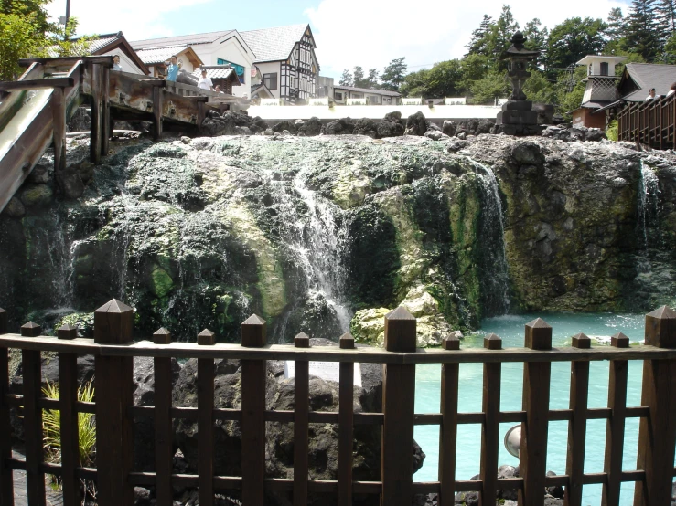 there are lots of people standing at the base of this waterfall