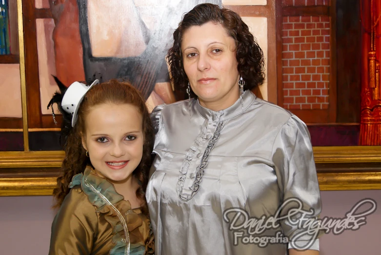 a woman in a silver dress standing next to another woman