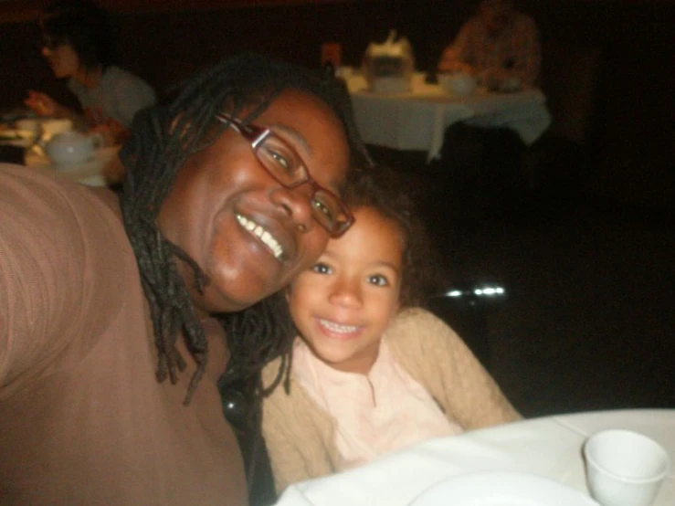 a woman with long dreadlocks posing for a po with her child