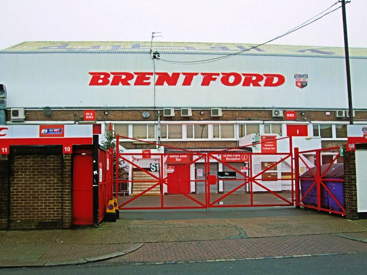 a brown brick building with red gates in front