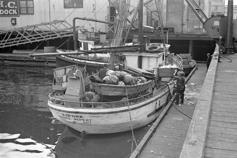 black and white pograph of boats tied up to dock