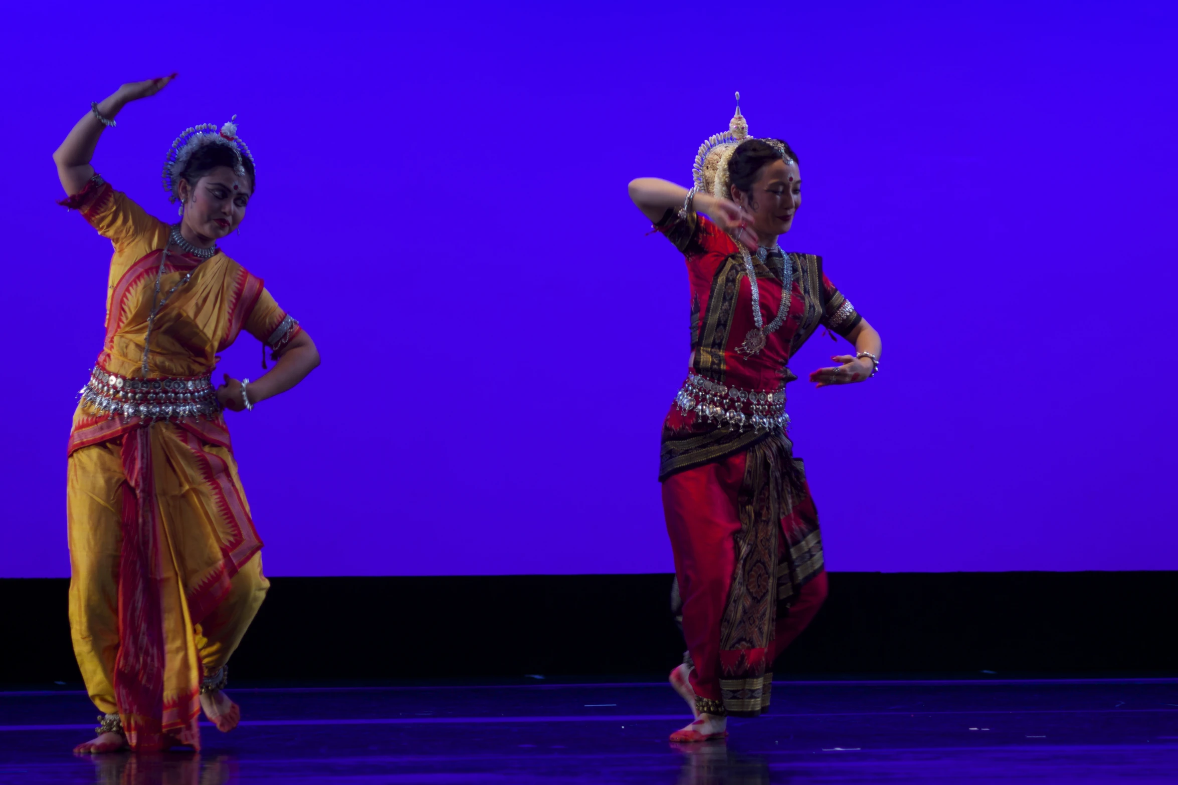 two women perform indian dance on stage