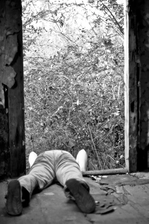 a man laying on the ground in front of an open doorway