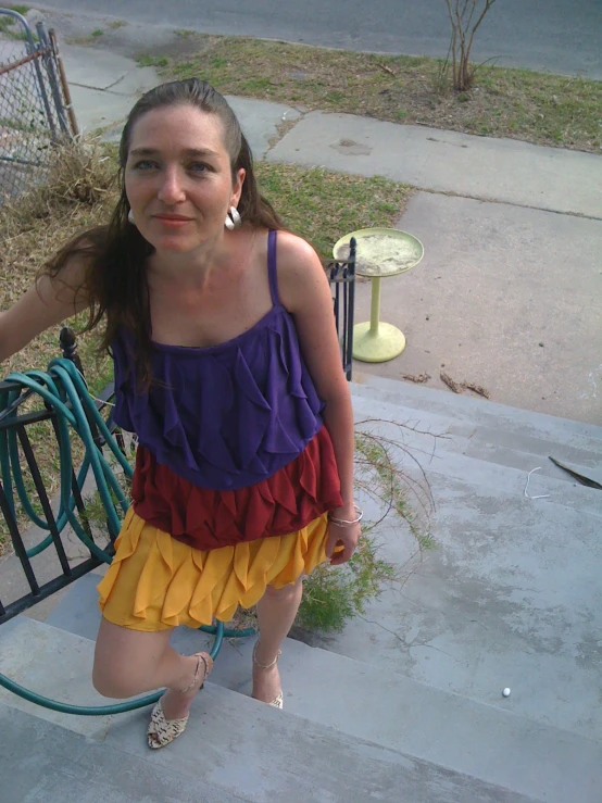 a  in yellow and purple outfit sitting on steps