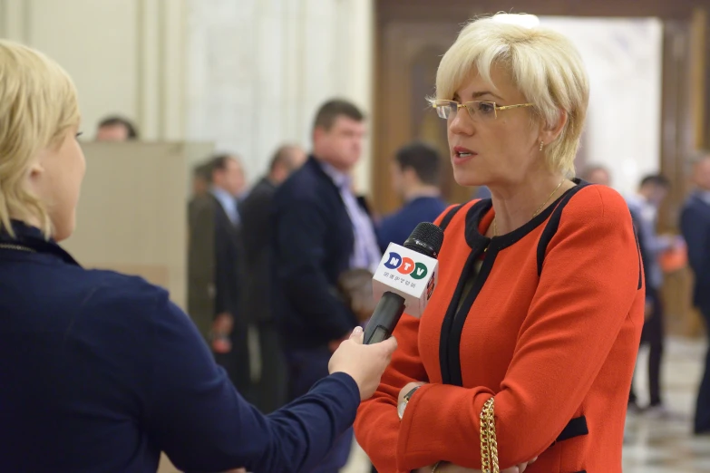 a woman talking to an reporter about the news