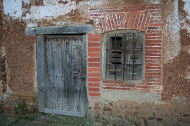 the window of an old brick building with bars on it